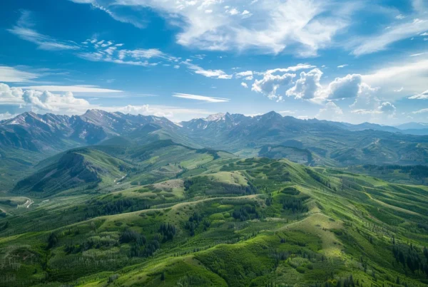 a majestic aerial view showcasing a vibrant, mountainous landscape under a brilliant blue sky, captured from the perspective of a helicopter during a scenic flight.